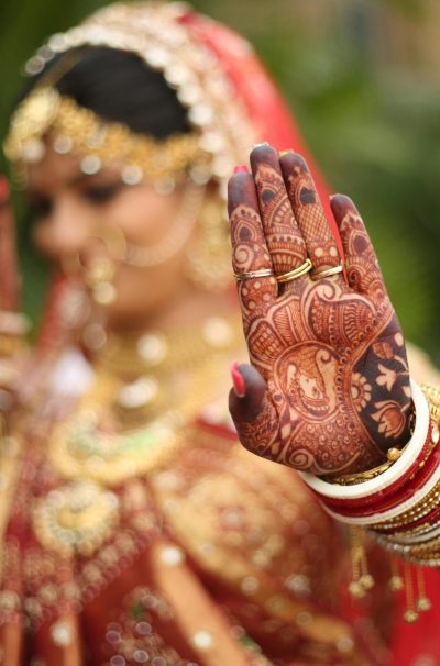 A detailed shot of an Indian bride's henna-decorated hands with traditional jewelry, showcasing cultural richness.